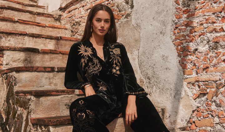 Models wearing black velvet button down and embroidered velvet pant