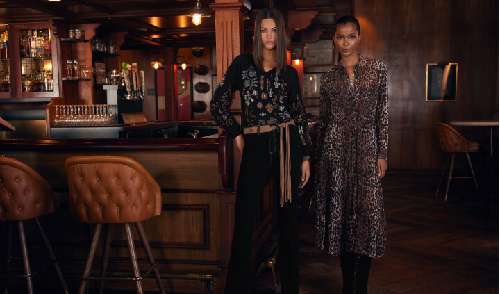 Models wearing black embroidered blouse and animal printed dress