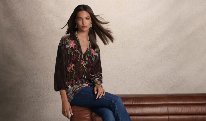 Model wearing olive green embroidered button down blouse and denim