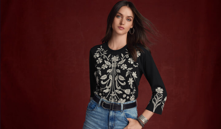 Model wearing black and creme embroidered blouse
