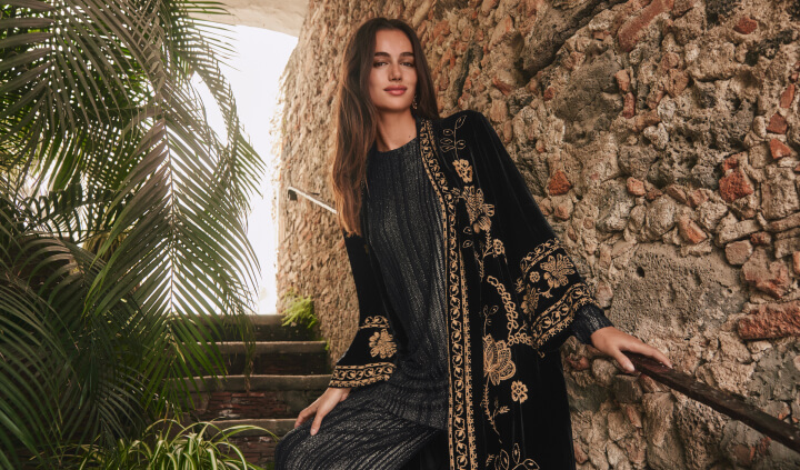 Model wearing a black metallic set and black embroidered velvet kimono coat